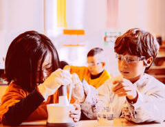 Deux enfants faisant une expérience de sciences en classe.