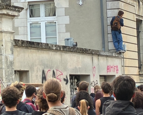 Photo de lycéens manifestant devant un mur tagué "Antfia" et "ACAB".