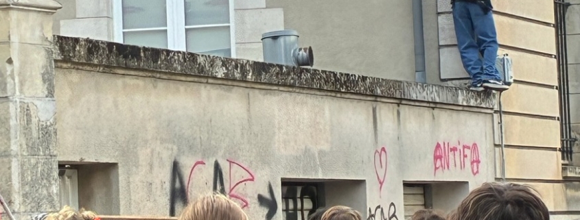 Photo de lycéens manifestant devant un mur tagué "Antfia" et "ACAB".